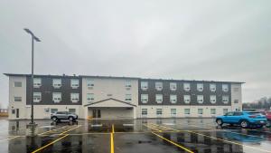弗朗西斯堡Studio 6 Fort Frances ON的一座大型建筑物，停车场里停满了汽车