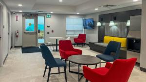 een wachtkamer met rode stoelen en een tafel bij Studio 6 Fort Frances ON in Fort Frances