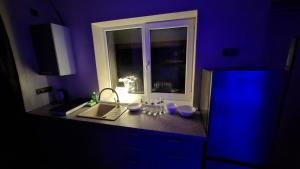 a purple kitchen with a counter and a window at Edelweiss Vila Šventoji in Šventoji