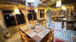 a dining room with a table and some windows at Hotel Soleil Blue in Boumalne Dades