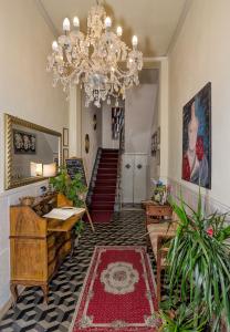 uma sala de estar com um lustre e uma escadaria em B&B La Mimosa em Lucca