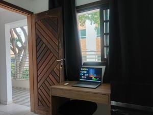 a laptop computer sitting on a desk next to a door at Suíte casal Bela Vista 207 in São Paulo