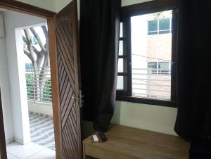 a room with a door and a window with a tree at Suíte casal Bela Vista 207 in São Paulo
