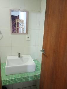 a bathroom with a white sink and a mirror at Suíte casal Bela Vista 207 in São Paulo