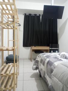 a bedroom with a bed and a ladder next to a desk at Suíte casal Bela Vista 207 in São Paulo
