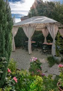 a pavilion with a table and chairs in a garden at B&B La Mimosa in Lucca