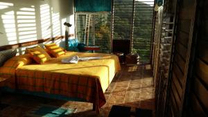 a bedroom with a bed in a room with windows at Celeste Mountain Lodge in Bijagua +67 photos