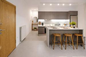 卡拉马塔Singer Suite Kalamata , Close to Center & Easy Street Parking的一个带三把酒吧凳子的小岛的厨房