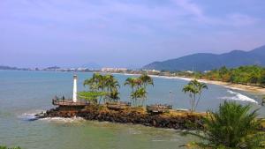 a lighthouse on a small island in the water at Hospedagem Mandala in Ubatuba