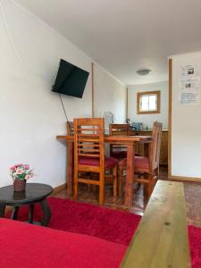 a living room with a wooden table and chairs at Cabañas Montesol Mejor Vista a las estrellas in Choapa
