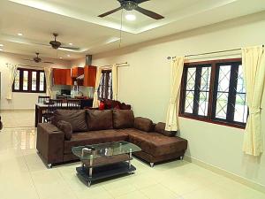 a living room with a brown couch and a table at Jasmine's Bungalow in Ban Saiyuan (1)