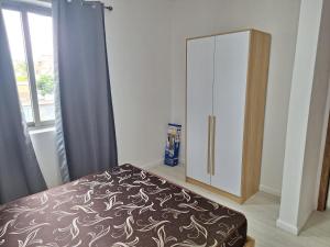 a bedroom with a bed and a cabinet at Lumea Apartment in Flic-en-Flac +5 photos
