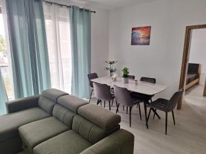 a living room with a couch and a table with chairs at Lumea Apartment in Flic-en-Flac