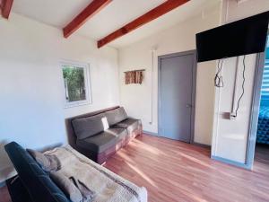 a living room with a couch and a flat screen tv at Cabaña Los Lagos 2 in Lenca