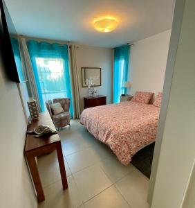 a bedroom with a bed and a chair at Flo location Fréjus in Fréjus
