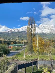 a view of snow covered mountains from a road at Duplex lo de Aaron in El Bolsón
