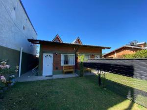 a house with a white door and a fence at Duplex lo de Aaron in El Bolsón +4 photos