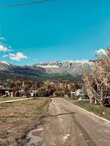 an empty road with a mountain in the background at Duplex lo de Aaron in El Bolsón