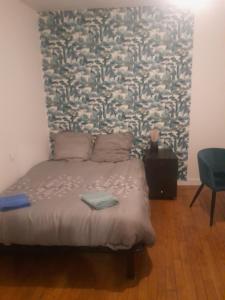 a bedroom with a bed with a large wall at Le studio du cinéma in Évron