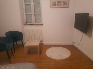 a living room with a small table and a tv at Le studio du cinéma in Évron