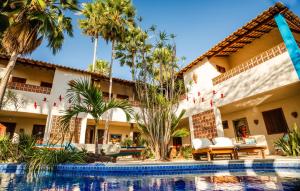 a resort with a swimming pool and palm trees at Pousada Vila Parnaíba in Parnaíba