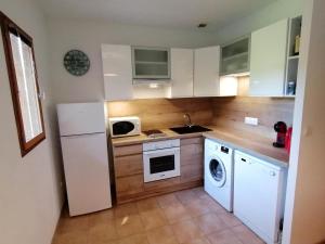 a kitchen with a white refrigerator and a microwave at MAISON ALBA ROSSA 55 in Serra-di-Ferro