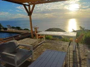 a patio with a table and chairs and a view of the ocean at Kevio in Chambort +6 photos