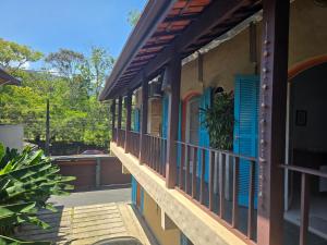 a building with blue windows and a balcony at Suites Nativa in Ubatuba