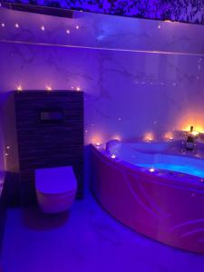 a purple bathroom with a tub and a toilet at Star&spa in Niš