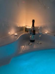 a bottle of wine and two glasses in a tub at Star&spa in Niš