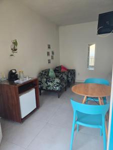 a living room with a couch and a table and chairs at Suites Nativa in Ubatuba