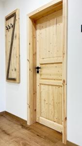 a wooden door in a room with a clock on a wall at Panorama Tatry Apartment in Jezersko