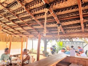 a group of people sitting at a table in a restaurant at location weligama in Weligama