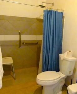 a bathroom with a toilet and a blue shower curtain at Primer Canto B&B - Near Ferry & Early Birdwatching Trails in Lepanto +45 photos