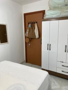 a bedroom with a bed and a closet and a door at Quarto sala Centro in Guarapari