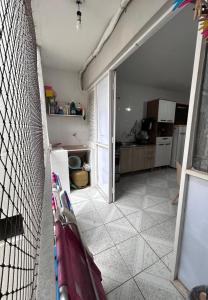 a room with a kitchen with a door open to a room with a kitchen at Quarto sala Centro in Guarapari