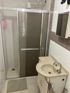 a bathroom with a shower and a sink at Quarto sala Centro in Guarapari