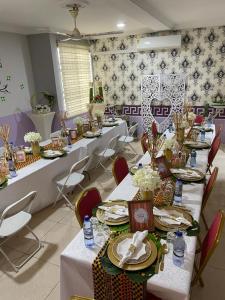 a room with long tables and chairs with flowers on them at Osprise Residencies in Tema