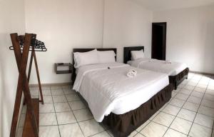 due letti in una stanza con una macchina fotografica su un treppiede di Tikva Hotel a Cuenca