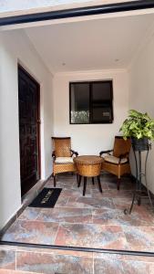 a living room with two chairs and a television at Moya Guesthouse in Johannesburg