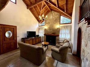 a living room with two chairs and a fireplace at Casa en Bosque de Pinos in San Carlos de Bariloche