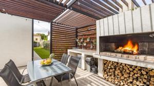 a patio with a fireplace and a table and chairs at Villa Kali in Krnica
