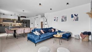 a living room with a blue couch and a kitchen at Villa Kali in Krnica