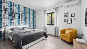 a bedroom with a bed and a yellow chair at Villa Kali in Krnica +37 photos