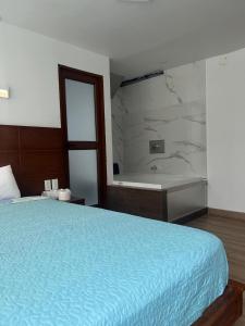 a bedroom with a bed and a bath tub at Hostal Bryana Inn Baños in Baños +25 photos