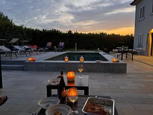 patio con tavolo, bicchieri da vino e piscina di I Grappoli a Canelli