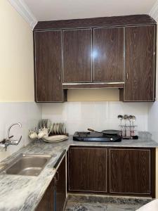 a kitchen with wooden cabinets and a sink at Elysium Inn in Abbottabad +27 photos