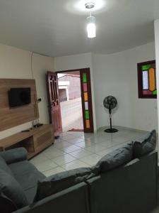 a living room with a couch and a tv at Casa Japaratinga in Japaratinga