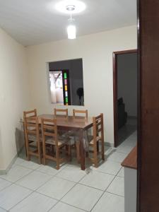 a dining room with a wooden table and chairs at Casa Japaratinga in Japaratinga