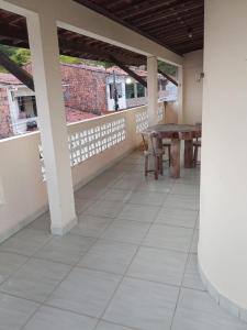 an empty porch with a table and chairs at Casa Japaratinga in Japaratinga